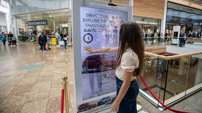 young girl using hand gestures in front of digital ooh advertising example